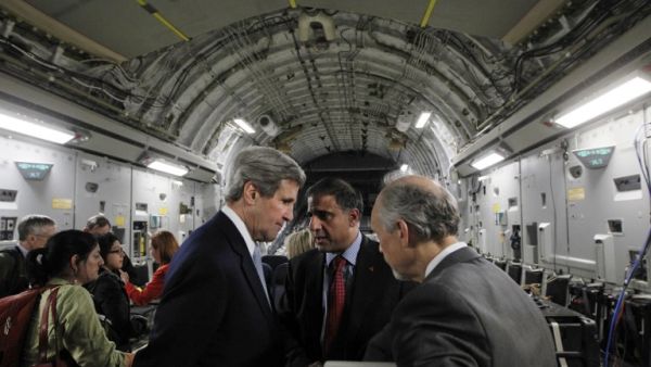 U.S. Secretary of State John Kerry speaks with Puneet Talwar (C), the National Security Council's Senior Director with responsibilities for Iran, Iraq, and the Gulf countries, and another advisor aboard an Air Force C-17 aircraft during their return to Amman from a trip to Baghdad. (AFP PHOTO/JASON REED/POOL)