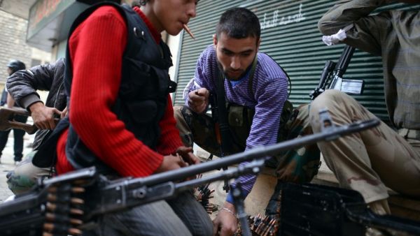 Rebel fighter load their weapons in the Sheikh Maqsud neighborhood in Aleppo on April 4, 2013. (AFP PHOTO / DIMITAR DILKOFF)