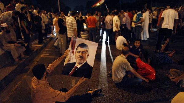 An Egyptian supporter of deposed president Mohammed Morsi holds his portrait during a sit-in protest outside the presidential palace in Cairo on July 13, 2013 (AFP/PHOTO/MAHMOUD KHALED)