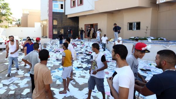 LIBYA, Tripoli : Libyan protesters stand amidst scattered documents after ransacking the offices of Muslim Brotherhood-backed Party of Justice and Construction, in the Libyan capital Tripoli on July 27, 2013. AFP PHOTO/MAHMUD TURKIA