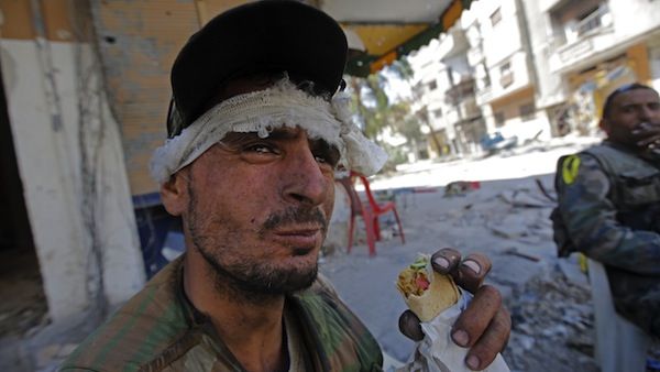 A Syrian government forces soldier eats a sandwich on July 31, 2013 in the al-Khalidiyah district of Syria's central city of Homs. (AFP)
