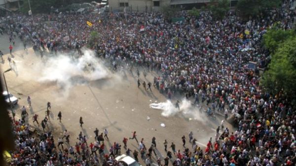 EGYPT, Cairo : Egyptian Muslim brotherhood and supporters of ousted president Mohamed Morsi run for cover from tear gas during clashes with riot police along Ramsis street in downtown Cairo, on October 6, 2013 (AFP)
