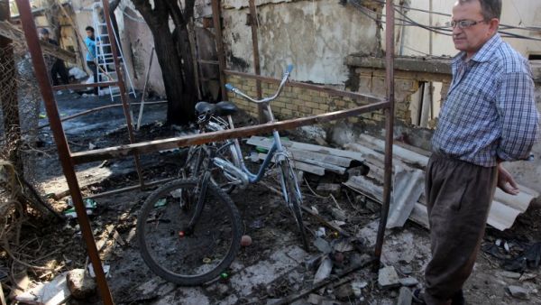 An Iraqi man inspects the site of a car bomb explosion in the Taubchi neighbourhood of the capital Baghdad on January 19, 2014, a day after the attack. [AFP]