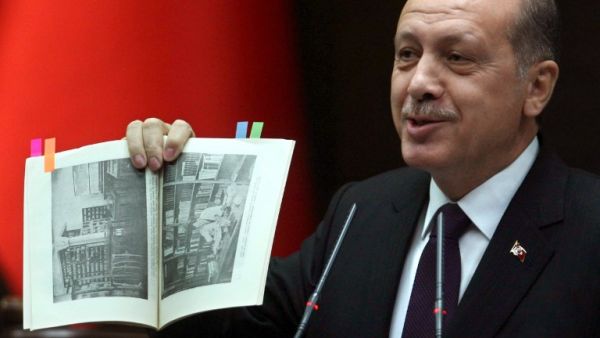 Turkish Prime Minister Recep Tayyip Erdogan shows a book from the Turkish Anthropology Institutes during an address to his ruling party. (AFP PHOTO / ADEM ALTAN)