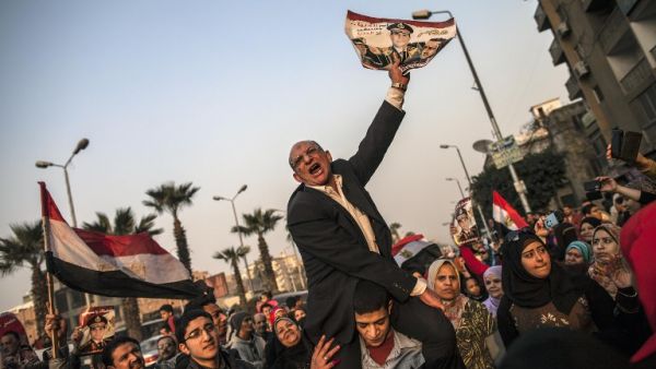 An Egyptian man holds a portrait of Egypt's Defense Minister General Abdel Fattah al-Sisi outside a polling station during the vote on a new constitution. [AFP]