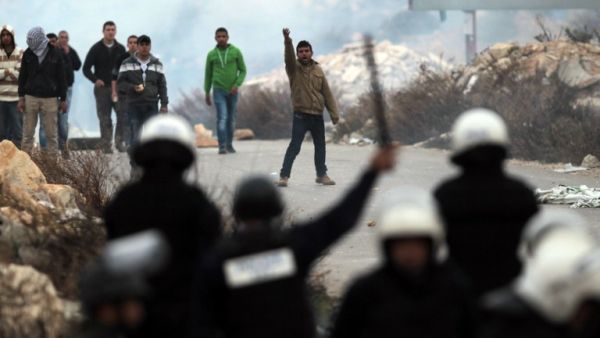 Youth from the Palestinian refugee camp of al-Jalazoun, clash with Palestinian police as they block the main road leading to the West Bank city of Ramallah and Bir Zeit as they protest against the reduction of aid to refugees given by United Nation's UNRWA on January 12, 2014. [AFP]