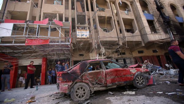 Iraqi civilians check the site of an explosion in Baghdad on Wednesday. Coordinated car bombs ripped through mostly Shiite neighbourhoods in the Baghdad area during rush hour, killing at least 30 people, the latest in spiralling violence in recent months. (AFP)