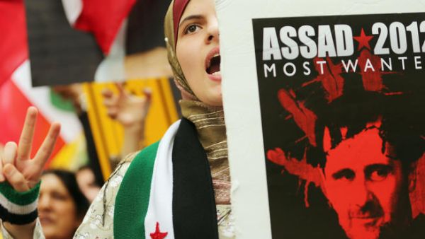 Protestors outside the UN General Assembly in New York hold anti-Assad signs