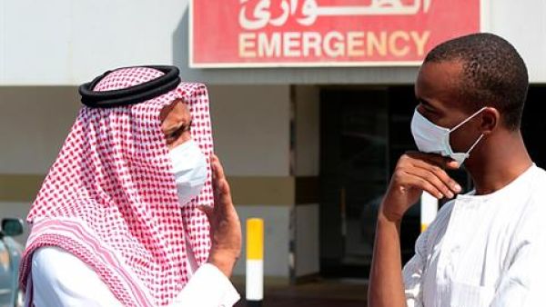 Men wearing surgical masks as a precautionary measure against the novel coronavirus, speak at a hospital in Khobar city in Dammam May 23, 2013. 