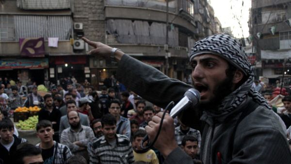 A member of the Islamic State of Iraq and the Levant (ISIL) speaks into a microphone urging people to join their fight against the regime, in the northern Syrian city of Aleppo on November 13, 2013. [Getty Images]