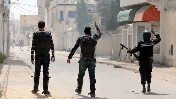 Security forces gesture towards Ansar Al Sharia protestors in the Ettadhamen, Tunisia on Sunday. AFP