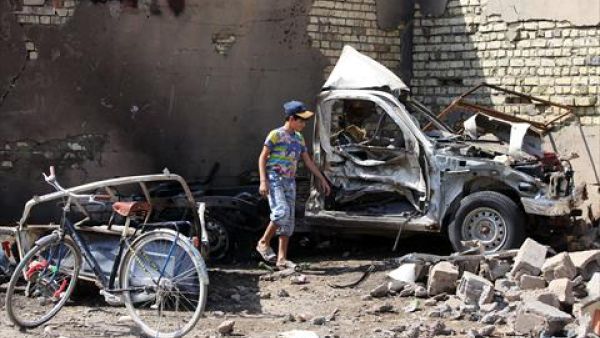 An Iraqi child stands by the wreckage of a burnt car on the site of a car bomb explosion in the city of Suweirah, south of Baghdad, on Sunday. A wave of attacks across Iraq, including more than a dozen car bombs, killed at least 30 people while the head of Baghdad's provincial council escaped assassination. (AFP)