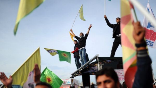 Kurdish people hold flags and shout slogans as they gather to support Syrian Kurds on November 24, 2013. [AFP]