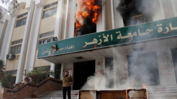 A man stands outside a faculty building at Cairo's Al-Azhar University after student supporters of the Muslim Brotherhood stormed it on December 28, 2013. [AFP]