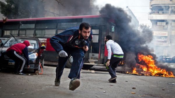 Supporters of Egypt's deposed president Mohamed Morsi run for cover from tear gas fired by riot police during clashes in the northeastern part of Cairo's Nasr City district on January 3, 2014. [Getty Images]