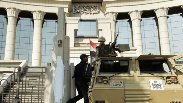 An Egyptian policeman talks to a soldier manning an armoured personnel carrier outside the Egyptian Constitutional Court in Cairo on Monday (AFP photo)