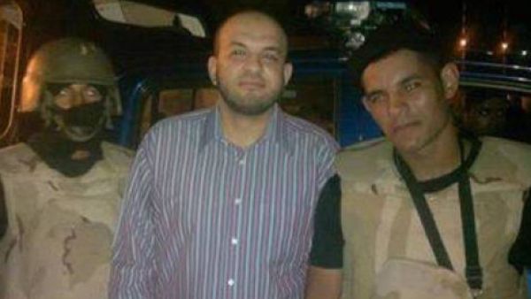 Ahmed Arif is seen smiling with the police that arrested him. (Egyptian police Facebook)