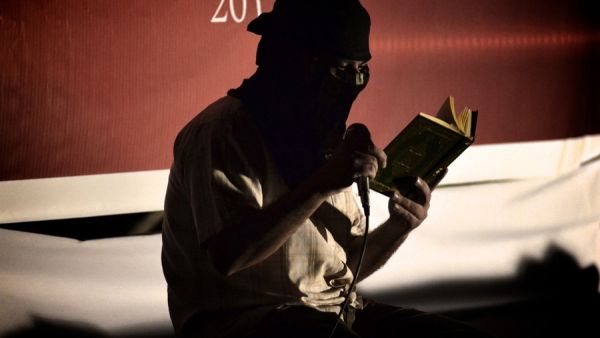 A Shiite Muslim reads the Quran before starting an anti-government rally in 2012. According to recent reports, government forces have damaged a prominent Shiite shrine. (AFP/File)