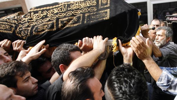 Mourners carry the body of Hassan Ramadan, who was killed in a blast in Beirut earlier in the week, during a funeral in the southern Lebanese village of Jwaya (AFP/MAHMOUD ZAYYAT)