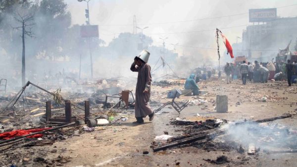  supporter of Egypt's ousted president Mohamed Morsi walks through the debris following clashes with police in Cairo on August 14, 2013. (AFP)