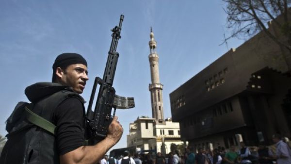 An Egyptian armed policeman holds a position in front of a burnt police station in the village of Kerdasa on the outskirts of Cairo, on September 19, 2013. (AFP)
