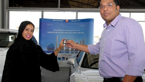 Huda Abdulla, Executive Vice President - Branch Distribution at First Gulf Bank presenting one of the half yearly draw winners with an Audi R8 Quattro Huda Abdulla, Executive Vice President - Branch Distribution at First Gulf Bank presenting one of the half yearly draw winners with an Audi R8 Quattro