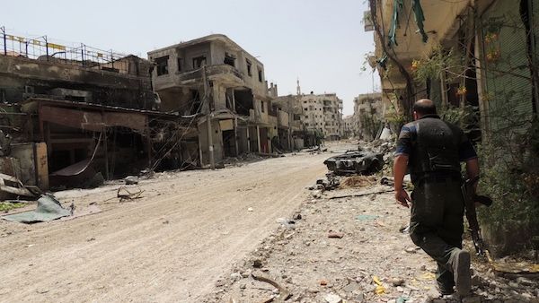 A Syrian rebel walks in a heavily damaged street in Arbeen in the outskirts of Damascus . AFP Photo