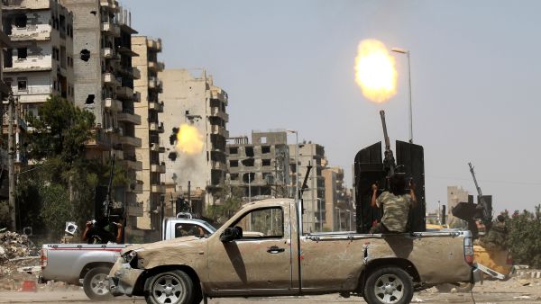 A Syrian rebel fires as a regime fighter jet flies overhead in Syria's eastern town of Deir Ezzor, on August 17, 2013. (AFP)