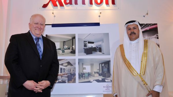Ed Fuller and Shaikh Hisham Abdulrahman Al-Khalifa beside the renderings of The Residence Inn by Marriott Juffair