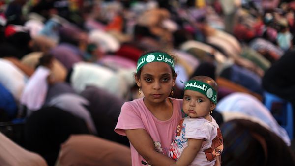 An Egyptian girl holds a baby as supporters of the Muslim Brotherhood pray on July 10, 2013. (source: AFP PHOTO / MAHMUD HAMS)