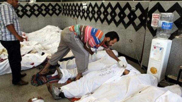 Men check the IDs of dead Muslim Brotherhood supporters, at a field hospital in Cairo, on July 27, 2013 (AFP)