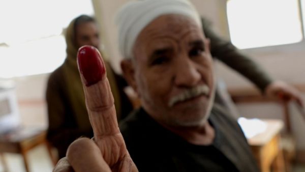 An Egyptian man holds up his finger, proving he has voted in the constitutional polls in his local Cairo voting station. (AFP)