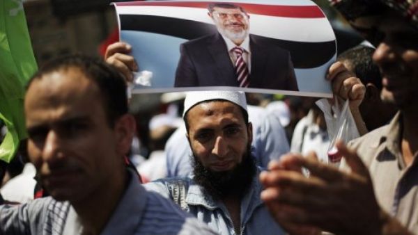 A protester is seen with a picture of President Mohamed Morsi, at the Rabaa al-Adawiya mosque in Cairo, on June 28, 2013 (AFP/File)