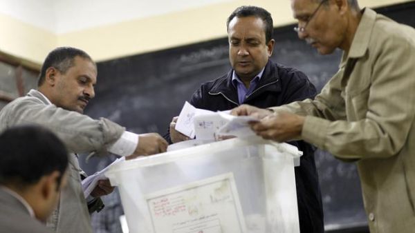 Polling station officials count ballots in Cairo on Saturday at the end of the first day of vote in a referendum on a new constitution. (AFP PHOTO/MAHMOUD KHALED)