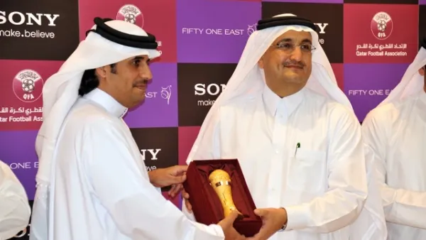 Mr. Khaled Al-Kuwari handing a miniature Emir's Cup to Mr. Bader as a token of QFA's appreciation