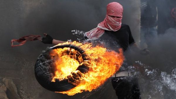 A Palestinian sets fire to a tyre during clashes between hundreds of Palestinians and Israeli soldiers earlier this year in Hebron. (file AFP)