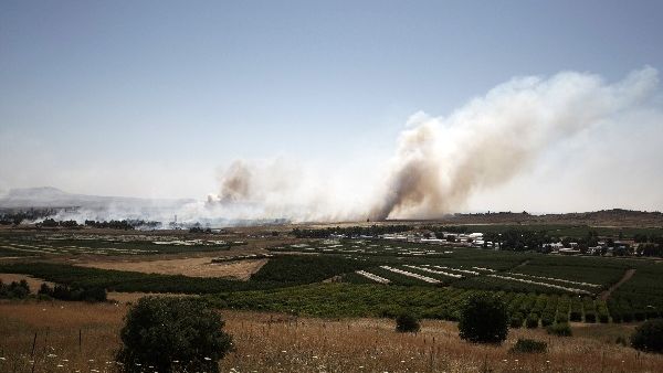 Smoke billows during clashes between Syrian rebels and forces loyal to the regime near the Quneitra crossing in the Golan Heights on Thursday. AFP Photo
