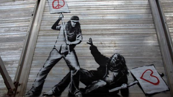 Art work said to be by underground artist Banksy is seen on the fence at the Glastonbury Festival site at Worthy Farm, Pilton on June 24, 2010 in Glastonbury, England.