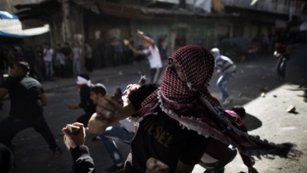 Palestinian stone throwers confront Israeli soldiers in the southern West Bank city of Hebron on September 23, 2013, as tensions run high following the death of an Israeli soldier. (AFP)