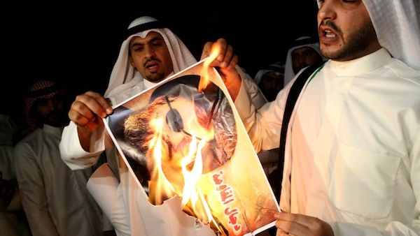 Kuwaiti protesters set ablaze a picture of Hezbollah's chief Hassan Nasrallah during a protest in front the Lebanese embassy against Hezbollah's and Iran's involvement in Syria on Tuesday. AFP photo