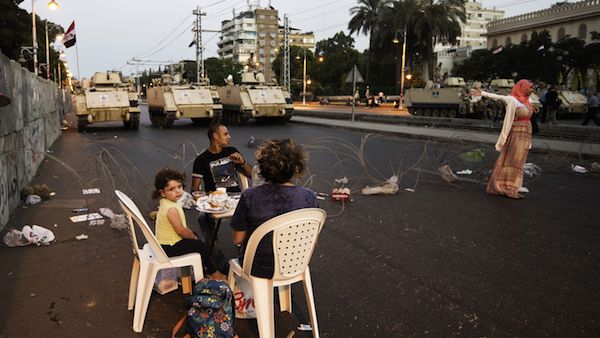 Egyptian army APCs are stationed outside the presidential palace as opponents of ousted president Mohamed Morsi gather to break their fast with the iftar meal in Cairo (Source: AFP/GIANLUIGI GUERCIA)