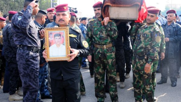 Military officers carry the coffin of a comrade during his funeral in the city of Nasiriyah, on December 31, 2013, after he was killed in fighting in the western Anbar province. (AFP)
