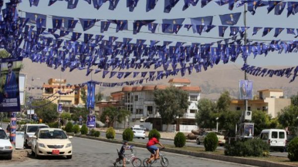 A Kurd young boy cross a street under blue flags, emblazoned with a candle, of the Movement for Change (MC) (aka Goran) displayed in the streets as part of the campaign for Kurdistan's parliamentary elections on September 18, 2013 in Iraq's northern city of Sulaimaniyah. (AFP)
