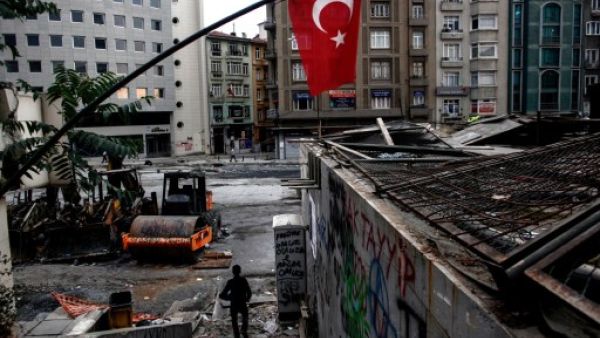 People walk next to Taksim's Gezi Park early on Wednesday in Istanbul, hours after riot police invaded the square. AFP image.