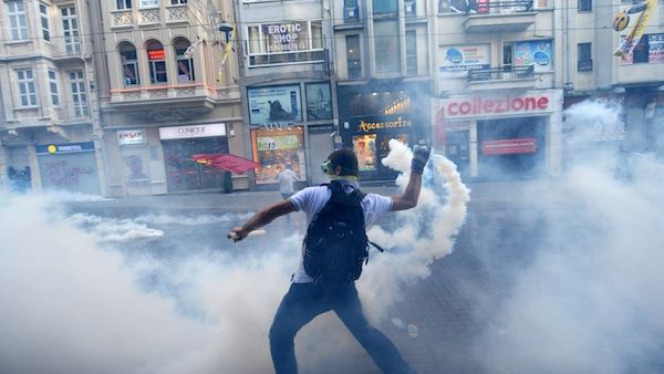 A protestor throws back a canister of tear gas to Turkish riot policemen during a protest against the demolition of Taksim Gezi Park on Friday.  AFP Photo