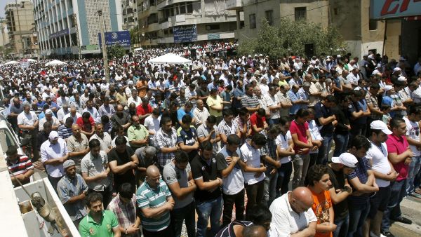 Supporters of Lebanon's radical Sunni cleric Sheikh Ahmad al-Assir perform the weekly Friday prayers as they gather to show their support to Assir in the southern city of Sidon on June 28, 2013. Lebanese security forces have launched a manhunt for Assir, after clashes with his supporters in Sidon killed 17 soldiers. (Source: AFP/MAHMOUD ZAYYAT)