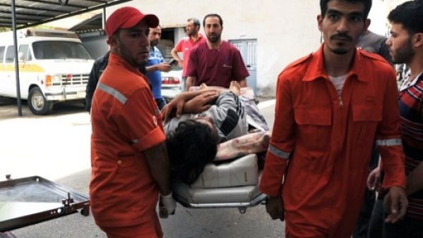 Lebanese Red Cross volunteers use a stretcher to move a Syrian, who was wounded in the nearby Syrian city of Qusair, from an ambulance upon their arrival at an hospital on Saturday. AFP Photo