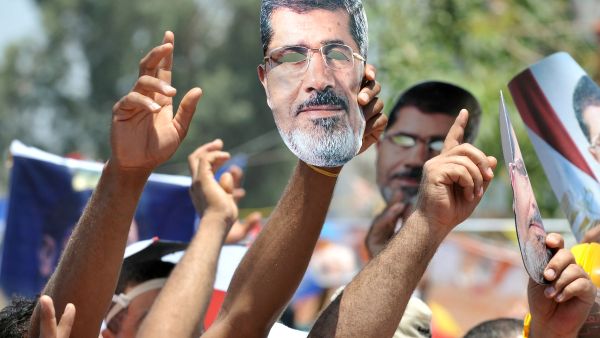 Supporters of deposed president Mohamed Morsi (portrait) shout slogans during a demonstration following Friday prayers in Cairo on July 26, 2013 (AFP)