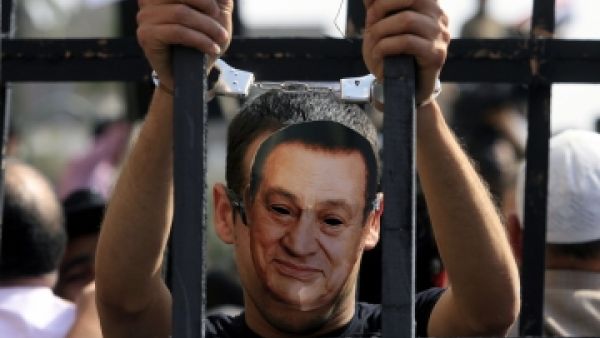 A critic of former Egyptian president Mubarak is seen wearing a mask of his face in Cairo. (AFP/File)