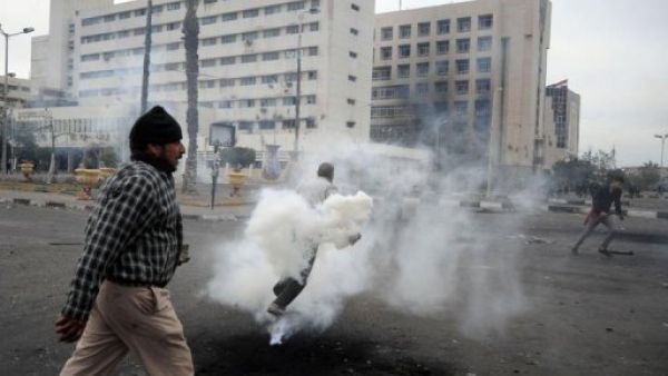 ارشيف/ مصري يمرر امام متظاهر يحاول ابعاد قنبلة غاز باتجاه قوات الشرطة